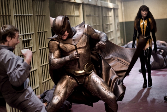 Nite Owl II (Patrick Wilson) fights off a rioting prisoner as Silk Spectre II (Malin Akerman) lends a hand.